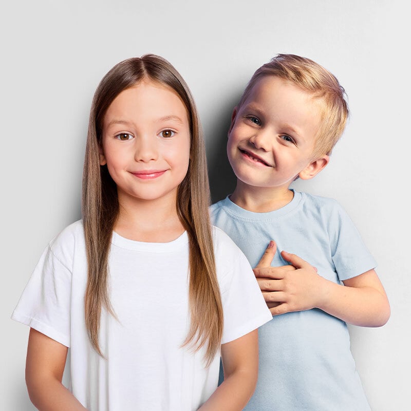 Två glada barn en pojke med blå t-shit och en flicka med långt brunt hår och bruna ögon